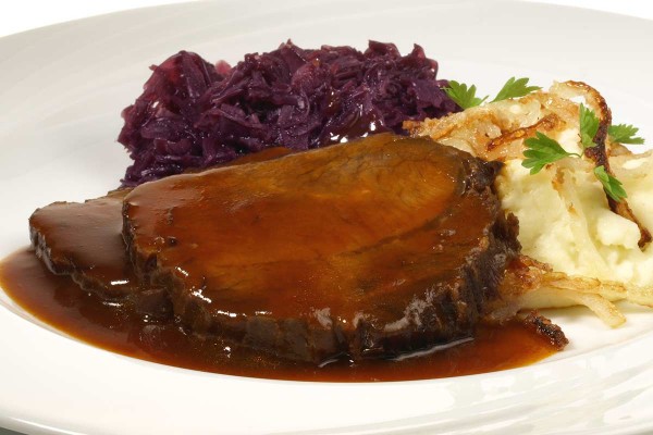 Spanferkelrollbraten mit Bratensoße, Semmelknödel und Rotkraut